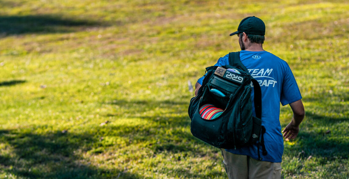 A black GRIPeq disc golf bag in use during a round of disc golf