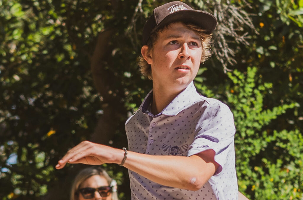 Kyle Klein releases a disc and is following the shot with his eyes. He is looking slightly to the right and upwards.