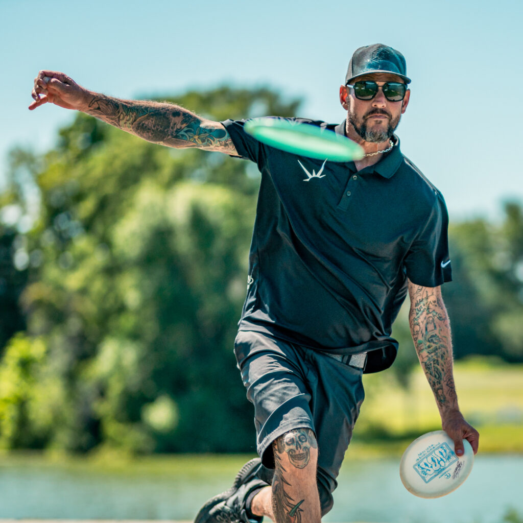 A front-facing view of Patrick Brown as he throws a tee shot off the tee pad.