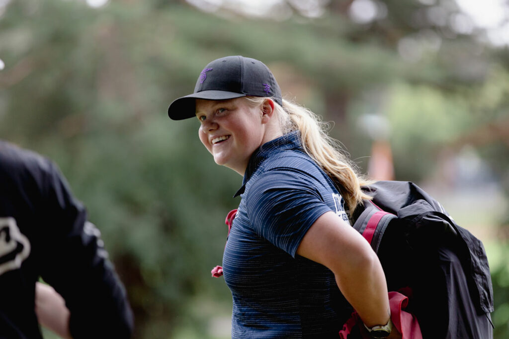 Team GRIPeq member Eveliina Salonen smiles as she puts on a pink GRIPeq bag.