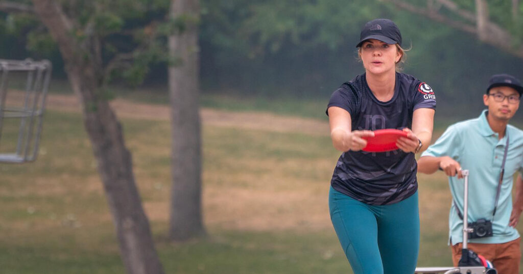 Jo Henderson lining up a disc golf putt.