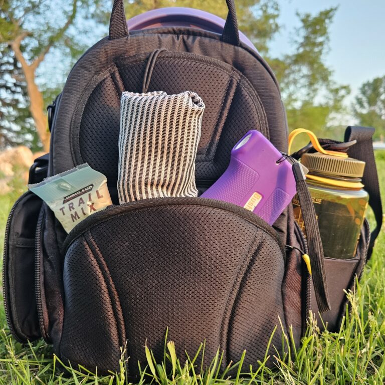 Back side of the G-Series bag, featuring the large back pocket. A pair of socks, snack, and a Bushnell are stored in the this bags back pocket.
