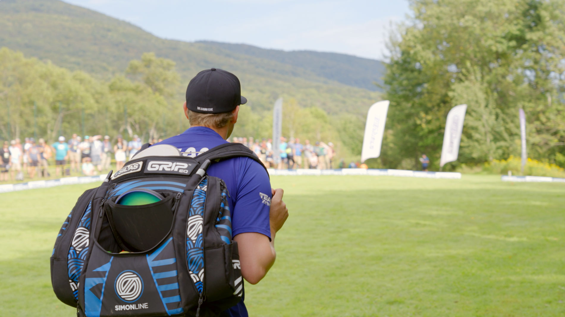 Simon Lizotte walks across the fairway with his Simon Line AX5 bag on his back.